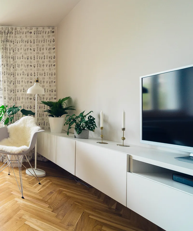 A bright, tidy living room with a blue sofa and light wood floor
