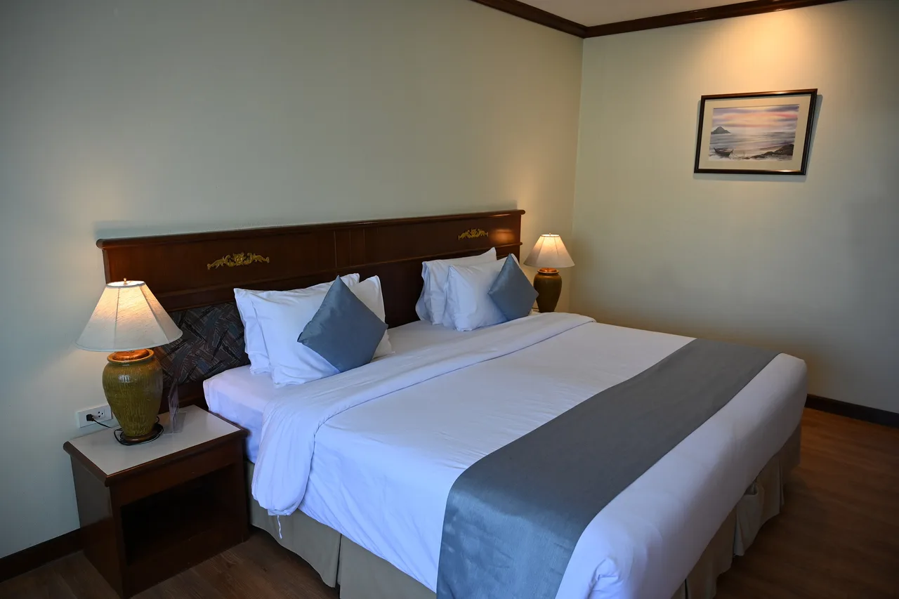 A neatly made guest bed with fresh white linens and bedside lamps